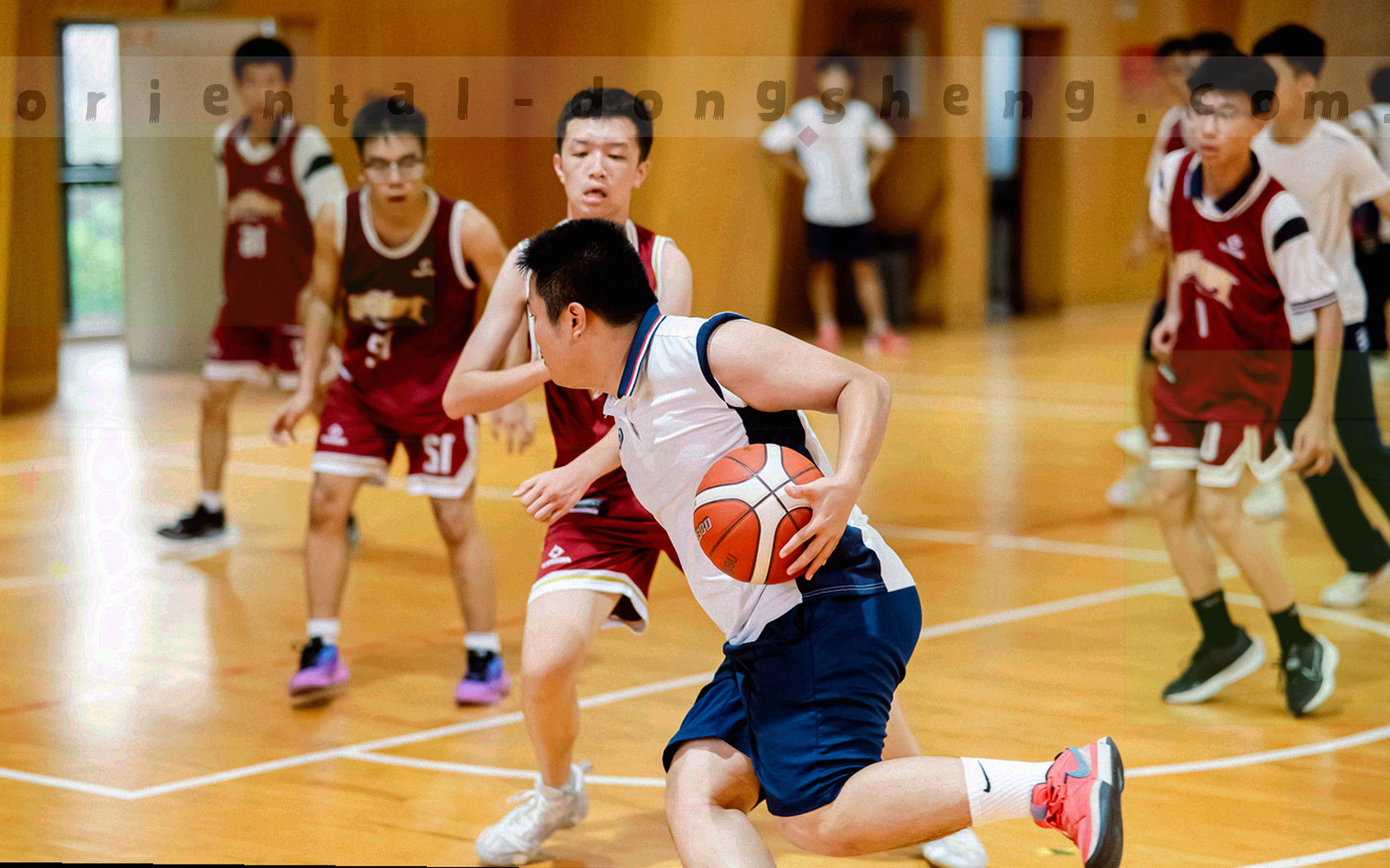 云南高原赛场航拍，跑道与看台沿对角线延伸，画面偏暖